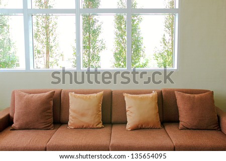 sofa in the living room with plant outside the windows