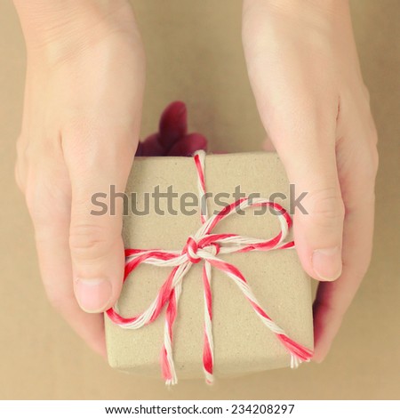 Hand holding gift box with retro filter effect