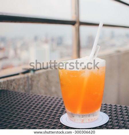 Cocktail glass in rooftop bar against city view