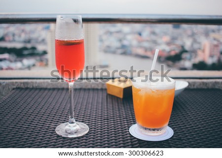 Cocktail glasses in rooftop bar against city view
