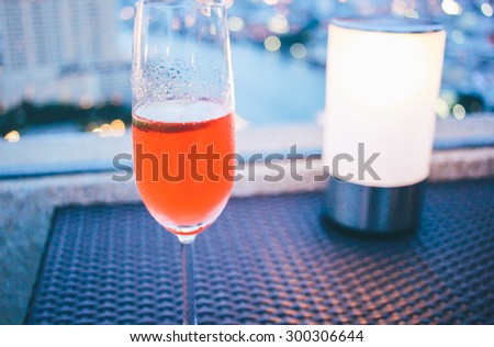 Cocktail glass with candle light in rooftop bar against city view