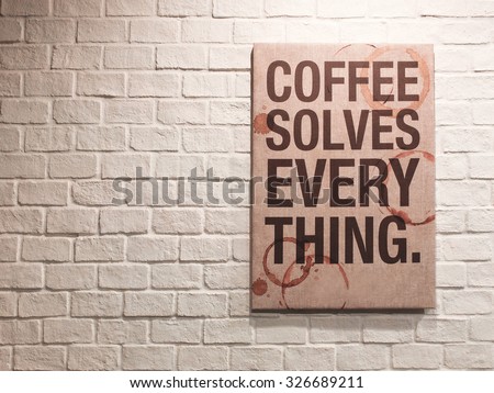 Inspirational motivating quote about coffee on canvas frame hanging on brick wall in the cafe