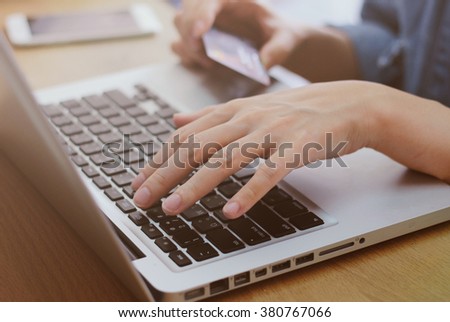 Woman's hands holding credit card and using laptop, online shopping concept