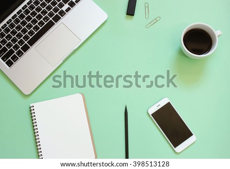 Creative flat lay design of workspace desk with laptop, blank notebook, smartphone, coffee, stationery with copy space background