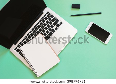 Creative flat lay design of workspace desk with laptop, blank notebook, smartphone and stationery with copy space background