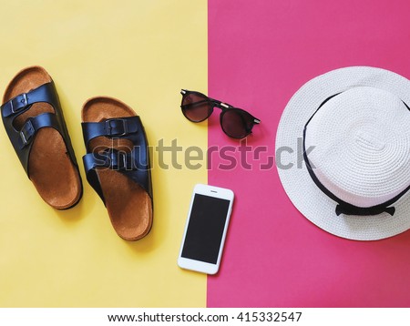 Flat lay style of summer accessories and travel items on colorful background