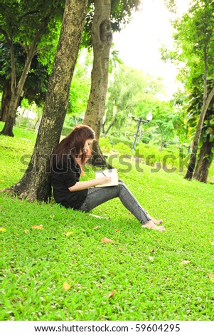 young woman studying and doing homework in the park