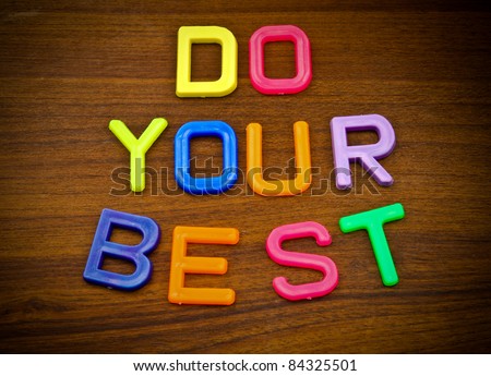 Do your best in colorful toy letters on wood background