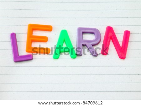 Learn in colorful toy letters on lined paper background
