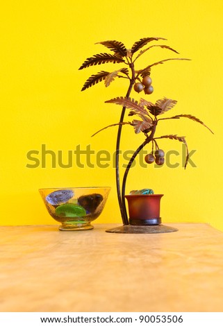 decorative metal tree with yellow wall