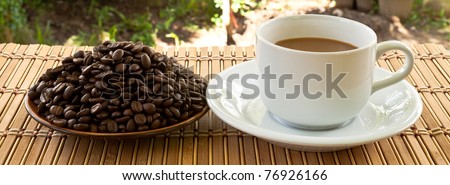 cup of coffee and coffee seed on plate