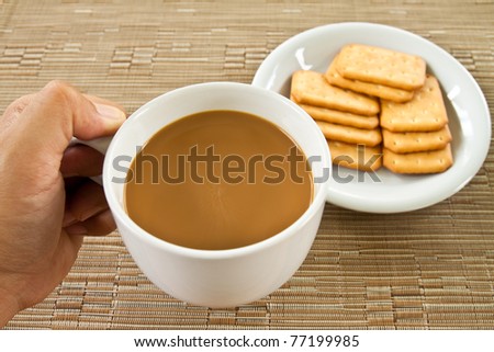 cup of coffee in hand and bread on plate