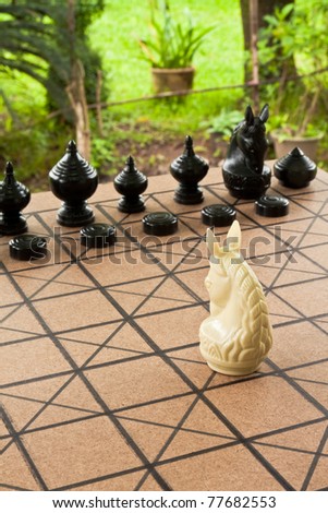 Single knight looking forward the chess board at the opposing pieces. A clipping path is included for easy extraction.