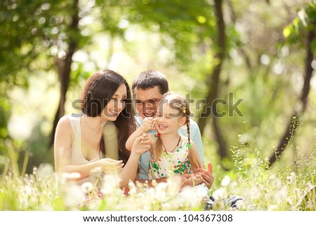 Happy Mother, Father And Daughter Playing In The Park
