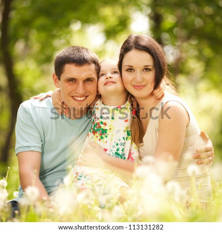 Happy mother, father and daughter in the park