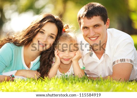Happy Mother, Father And Daughter In The Park