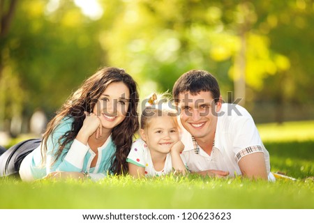 Happy mother, father and daughter in the park