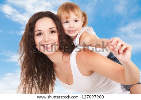 Happy mother and daughter playing on sky background