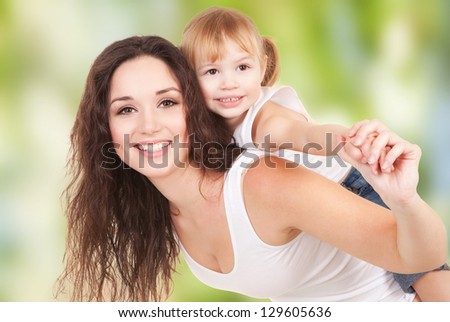 Happy mother and daughter playing on nature background