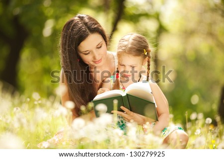 Mother With Daughter Read A Book In The Park
