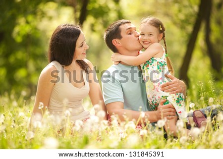 Happy Mother, Father And Daughter In The Park