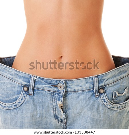Woman Shows Her Weight Loss By Wearing An Old Jeans, Isolated On White Background