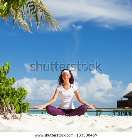 Pretty woman doing yoga exercises on the tropical beach Pretty woman doing yoga exercises on the tropical beach