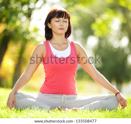 Pretty woman doing yoga exercises in the park Pretty woman doing yoga exercises in the park