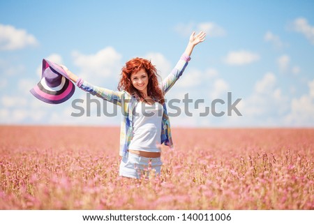 Cute woman in the field with flowers