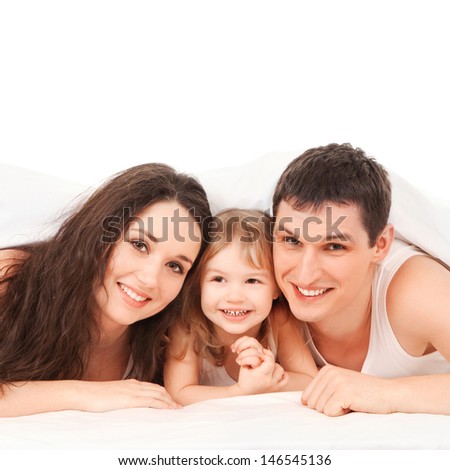 Happy family, mother, father and daughter resting on the white bed