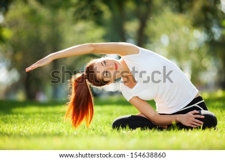 Pretty woman doing yoga exercises in the park Pretty woman doing yoga exercises in the park