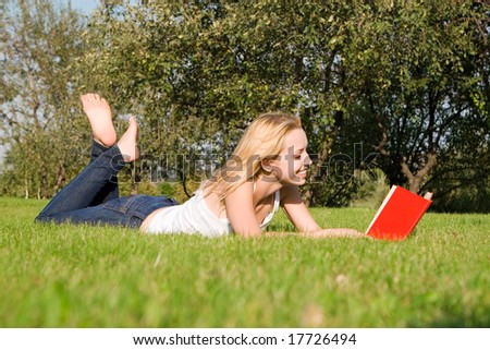 young blonde reads book in the park
