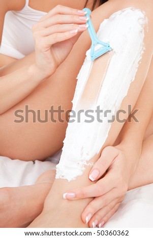 stock photo Cute woman shaving her legs