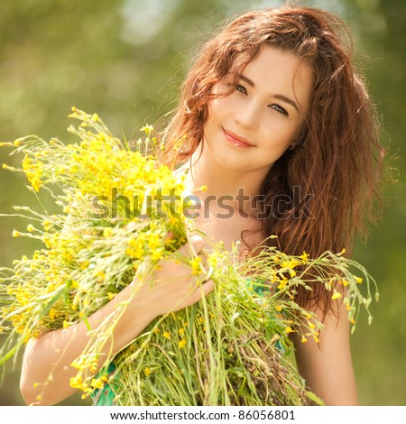 stock photo Young redhead woman in the park with flowers