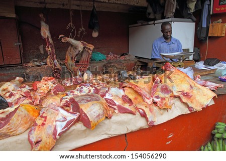 KAMPALA, UGANDA - SEPTEMBER 29, 2012. An African butcher works in his butcher shop in the food market of Kampala, Uganda on September 28,2012.