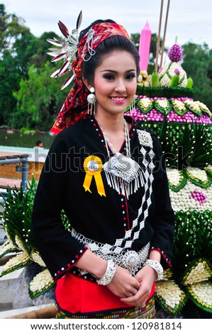 SUPHANBURi,THAILAND-NOVEMBER 28,2012: Cute girl in traditional costume in a carnival to celebrate the Loy Kratong Festival.she stay on a small rafts-Kratong. November 28, 2012 in Suphanburi, Thailand.