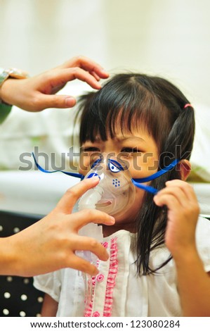 Nurse putting medical mask on child's face