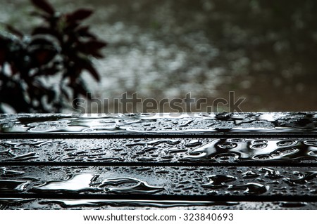 The water drops on wooden garden table, center focus for background.