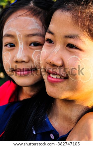 CHIANG RAI, THAILAND, NOVEMBER 30, 2015 : Unidentified two Burmese young girls in Thailand daub tanaka on her face. Tanaka is Burmese tradition cosmetic made from bark of tanaka tree.