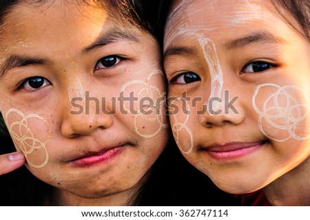 CHIANG RAI, THAILAND, NOVEMBER 30, 2015 : Unidentified two Burmese young girls in Thailand daub tanaka on her face. Tanaka is Burmese tradition cosmetic made from bark of tanaka tree.
