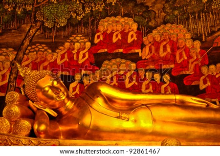 Reclining Buddha statue in a temple,Thailand.With a background as a priest.