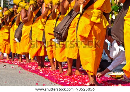BANGKOK,THAILAND-JAN 21:Row of Buddhist hike monks on streets strewn with rose petals on the Thammachai hike establish the path of the great teachers,On Jan 21,2011 in Bangkok