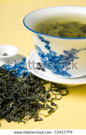 clay cup with green tea and tea leaves in dried tea leaves