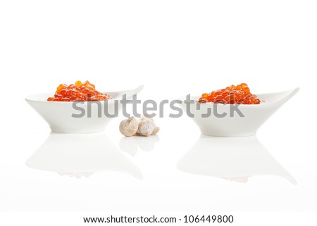 Delicious luxury food. Red salmon caviar in white bowls decorated with seashells isolated on white background. Luxury seafood concept