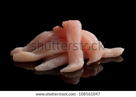 Raw chicken meat slices isolated on black background. Culinary gastronomy cooking background.
