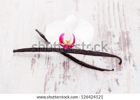 Dried vanilla fruit on white wooden textured background. Culinary aromatic food ingredient.