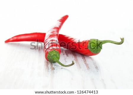 Culinary chili pepper background. Two chili pepper on white wooden background.