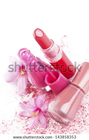 Pink and beige lipstick and nail polish with pink facial powder and flower isolated on white background. Girly make up and cosmetics still life.
