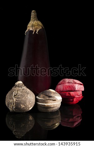 Delicious colorful fresh vegetable isolated on black background. Purple eggplant, black radish and cut beet. Healthy eating.