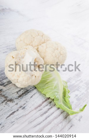 Fresh raw cauliflower isolated on white wooden background. Healthy raw food eating. Vegetable background, country style.